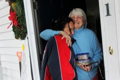 Treehouse resident Liz Poudrier hugs Sarah D?Amato,19, who had just delivered her a hot Thanksgiving meal. 

