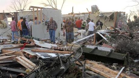 People inspect a storm-damaged home in the Roundaway community near Clarksdale, Miss., Wednesday, Dec. 23, 2015. A storm system forecasters called 