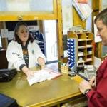 Karen Beauregard handed her mail to Bethlehem Postmaster Brian Thompson to run through an 1950's era machine to add a cancellation stamp to them. Bethlehem, N.H., draws visitors from hundreds of miles away for the cancellation mark during the holiday season. 