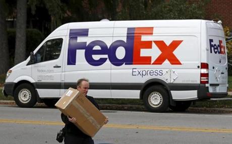 A FedEx delivery worker carrieds a package for a delivery in Wilmette, Illinois in October. 
