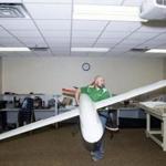 Ryan Walsh, an instructor at the Grand Forks Air Force Base, made sure that the wings of a SandShark unmanned aircraft had clearance in a classroom.