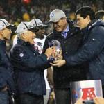 Foxborough, MA 01/18/15 Tedy Bruschi gives the AFC Championship trophy to Robert Kraft after the Patriots defeated the Colts 45-7 at Gillette Stadium Sunday, January 18, 2015. AFC Championship Game between the New England Patriots and the Indianapolis Colts . (Barry Chin/Globe Staff)