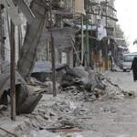 A woman walked past damaged shops in Syria this month.