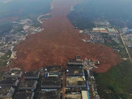 An aerial view shows the collapsed factory buildings brought down by the Dec. 20 landslide in Shenzhen, south China's Guangdong province. The search intensified for more than 91 people missing in southern China after a massive landslide buried around three dozen buildings in the city of Shenzhen. The number of rescue workers was boosted by around 1,200 to just over 2,900, the Xinhua news agency reported. Another 78 excavators arrived to help dig through 380,000 square metres of silt up to 10 metres deep, the deputy mayor of Shenzhen, told a press conference on Dec. 21. The landslide occurred when a large, unstable mound of dumped earth and construction rubbish collapsed, the Ministry of Land and Natural Resources said.
