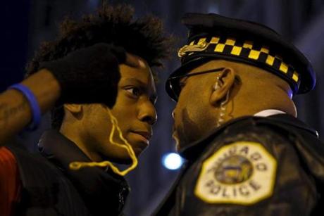 Protestors including Lamon Reccord, 16, confront police during a demonstration in response to the fatal shooting of Laquan McDonald in Chicago, Ill., on Nov. 25. Laquan McDonald, 17, was fatally shot by Jason Van Dyke, a Chicago police officer, in October 2014.
