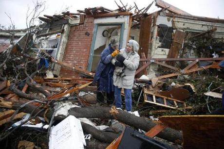 Pam Russell (left) and Linda Hart rescue Pam's cat, Larue, from Russell's house a day after a tornado hit on Delta Drive in Rowlett, Texas, on Dec. 27. At least 11 people died and dozens were injured in apparently strong tornadoes that swept through the Dallas area and caused substantial damage this weekend.
