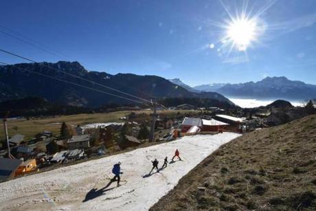 Tourists ski on a thin layer of snow towards the resort of Leysin, Swiss Alps, on Dec. 28. In a season traditionally associated with ice-skating, snowball fights and mulled wine in wintry Europe, birds are chirping, flowers blooming and fake snow covering Alpine ski slopes in one of the warmest Decembers on record. 
