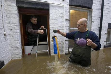 Workers from a taxi firm enter their premises with a teapot and cups of tea, which they have got from a neighboring wine bar, through the floodwaters from the rivers Foss and Ouse, after they burst their banks in York, northern England, on Dec. 28. British Prime Minister David Cameron visited the flood-hit historic city of York on Monday as cities, towns and villages across northern England battled to get back on their feet following devastating storms. Around 500 properties were flooded in York, one of Britain's top tourist attractions, on Sunday as two rivers burst their banks. Some residential streets became so inundated that cars were covered up to their roofs.
