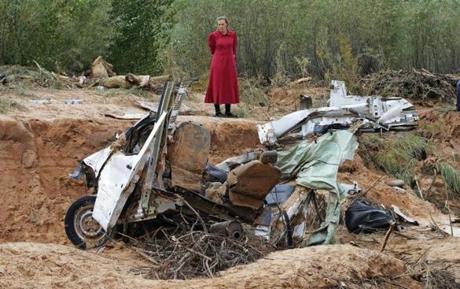 A woman looks at a damaged vehicle on Sept. 15 swept away during a flash flood in Hildale, Utah. A violent flash flood tore through the polygamous towns of Colorado City, Arizona, and Hildale, Utah, in September, sweeping away a van and SUV carrying three women and 13 children. Only three of the occupants survived as the vehicles were engulfed by floodwaters and carried down an embankment. 
