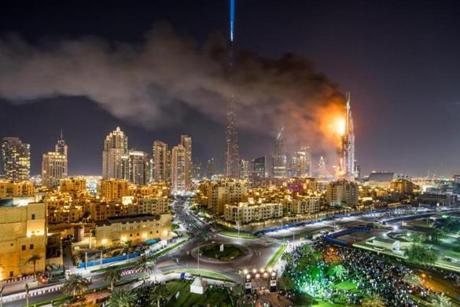 epa05084847 A general view of flames and smoke billowing from the building after fire broke out at The Address Hotel in Dubai, UAE. 31 December 2015. Media reports state that there is no immediate news of casualties. EPA/NICOLAS CORNET
