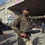 An Indian security personnel asks people to move away from the area outside the Indian Air Force (IAF) base on Sunday.