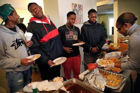 From left: Joseph Valbrun, 16; Chris Owens, 16; Leo Johnson, 14; and Osa Iyekekpolor, 17, lined up for seconds from teen coordinator DeLinda Sales during a holiday luncheon at the Dorchester YMCA last month.
