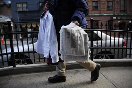 Globe reporter Josh Miller carried his suit and a bundle of Sunday Boston Globes to the State House as he arrived for an interview after spending the early morning hours helping fellow journalists worked to deliver the Sunday Boston Globe. 
