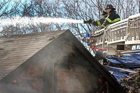 Firefighters sprayed down the roof at the scene of a fire on Essex Street in Saugus.
