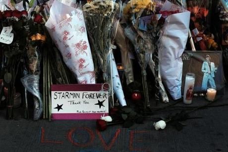 Flowers, candles, and pictures comprise a memorial set up Monday outside David Bowie?s New York apartment. 

