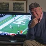 Portsmouth, N.H.--Mike Long, 77, who was an original Boston Patriot and the first to wear number 87, now assigned to superstar Rob Gronkowski wears an Patriots alumni cap as he watches the Pats play Philadelphia from his Portsmouth, N.H. apartment.