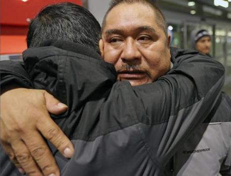 At Logan airport, Terminal A for a 5:45 am flight, Isidro Macario gives his son Isidro Jr, a hug goodbye.
