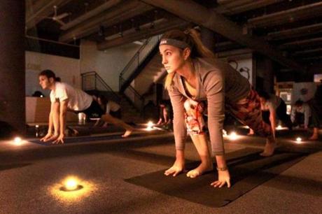 Julie Rosen ( foreground) took part in a candlelight yoga session at the community pop-up space known as POP Allston.

