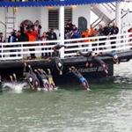 Competitors in the Escape from Alcatraz Triathlon jump into the water.