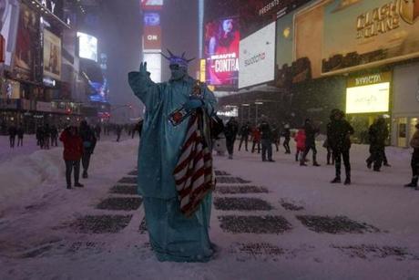 A man was seen posing as the Statue of Liberty during a snow storm in Times Square. 
