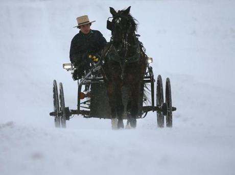 An Amish man drove his buggy through heavy snow and wind in Mechanicsville, Maryland. 
