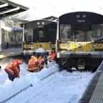 Workers cleared the tracks of snow at the Port Washington branch of the Long Island Railroad on Monday in Port Washington, N.Y.