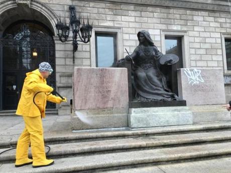 Workers cleaned graffiti off the front of statues at the Boston Public Library.
