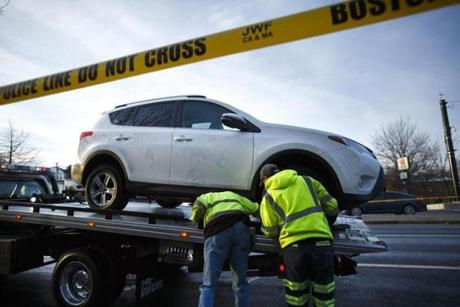 Workers removed a Toyota RAV-4 that police say was involved in a Monday morning incident in which two people were struck in Chinatown, with one of them being dragged to Dorchester. 
