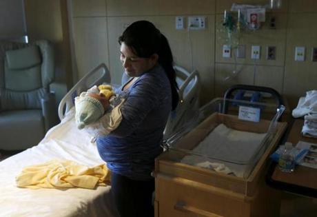 Nelsy Avendano of East Boston cradled her newborn son, Kevin Loaiza-Avendano, in her hospital room at Boston Medical Center last month.
