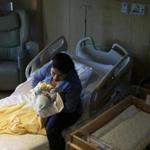 Nelsy Avendano of East Boston cradled her newborn son, Kevin Loaiza-Avendano, in her hospital room at Boston Medical Center last month.