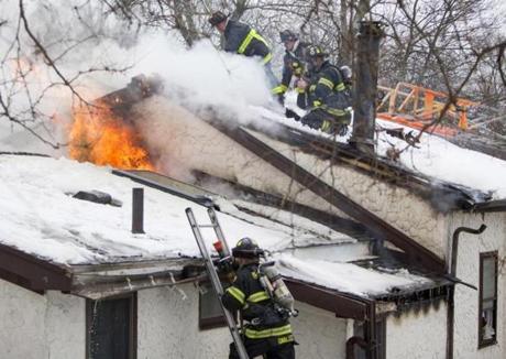 Firefighters from Dedham and Boston work to extinguish a 2-alarm house fire at 131 Bridge St. in Dedham on Monday, Feb. 15, 2015. (Scott Eisen for The Boston Globe)
