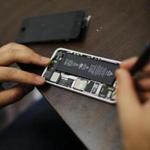 A worker tries to repair an iPhone in a repair store in New York on Wednesday. 