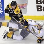 Boston Bruins left wing Brad Marchand (63) drops Nashville Predators center Filip Forsberg (9) to the ice during the first period of an NHL hockey game in Boston, Monday, Dec. 7, 2015. (AP Photo/Charles Krupa)