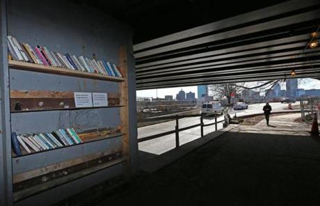 A small collection of books has appeared under the Cambridge side of the Longfellow Bridge. 
