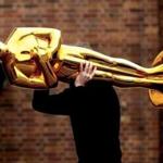 A worker carries an Oscar statue to a press event held by Filmstudios Babelsberg in Potsdam, eastern Germany. 