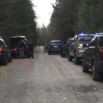 Police vehicles lined the road near a rural property in Belfair, Washington on Friday.