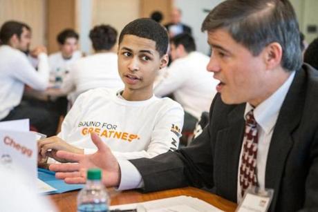 Victor Amaker (left) of Framingham High School listened to mentor Lino Covarrubias Friday during the launch of the 100 Males to College program, which was held at Framingham State University. 
