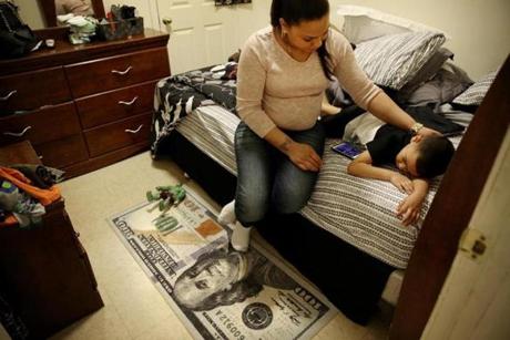 Lany Ruiz comforted her son, Alex, 5, in her bedroom at their home in the lower South End of Boston. 
