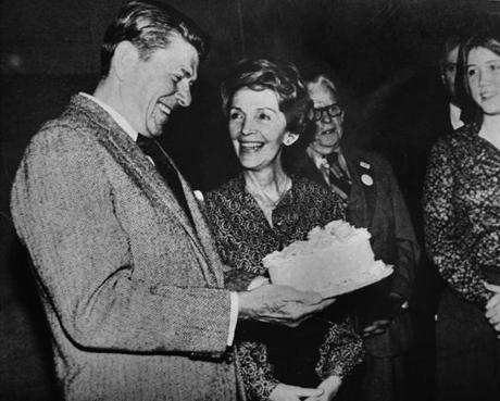 Then-GOP presidential hopeful Ronald Reagan held his birthday cake as his wife, Nancy, looked on at a campaign stop in 1980.
