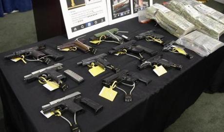 Weapons, money, and other items collected during a gang roundup were displayed after 48 members and associates of Boston's largest and most powerful gang, the Columbia Point Dawgs, were indicted on drug and gun charges in June 2015.
