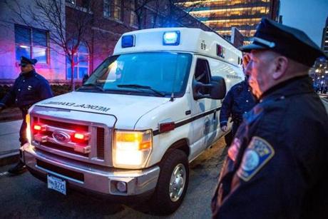  03/16/2016 BOSTON State Troopers walk beside an ambulance carrying the body of a Trooper killed earlier today during a traffic stop as it arrives at the morgue. Boston Police officers lined the intersection of Massachusetts Avenue and Albany Street in Boston. (Aram Boghosian for The Boston Globe)
