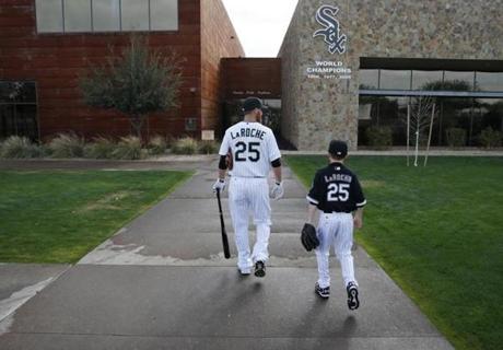 Former Chicago White Sox player Adam LaRoche and his son Drake walk to the clubhouse before a baseball spring training workout in Phoenix. 
