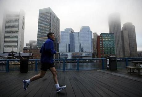 Boston, MA - 3/17/2016 - A man jogs along the Harborwalk in Fort Point channel as fog obscures the skyline in Boston, MA March 17, 2016. Jessica Rinaldi/Globe Staff Topic: Reporter: 

