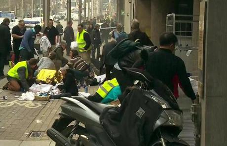 Rescue workers treat victims outside the Maelbeek metro station after a blast.
