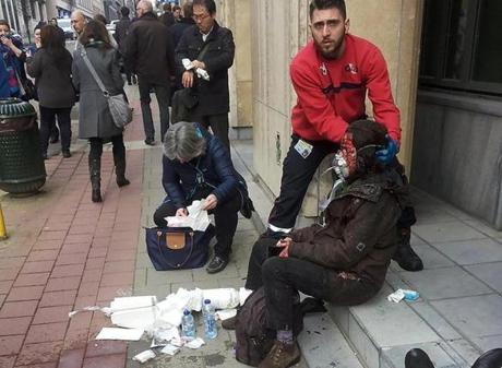 A private security guard helps a wounded women outside the Maalbeek metro station in Brussels on March 22 after a blast at this station located near the EU institutions. Belgian firefighters said at least 31 people had died after ?enormous? blasts rocked Brussels airport and a city metro station today, as Belgium raised its terror threat to the maximum level. 
