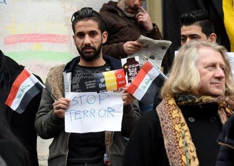 A man holds a placard and a Belgian flag during a gathering to pay tribute to the victims of the Brussels attacks on the Place de la Bourse (Beursplein) in central Brussels, on March 24, 2016, two days after a triple bomb attack, which responsibility was claimed by the Islamic State group, hit Brussels' airport and the Maelbeek - Maalbeek subway station, killing 31 people and wounding 300 others. A grieving Belgium hunted two fugitive suspects after bombings that struck at the very heart of Europe, as security authorities faced mounting criticism over the country's worst-ever attacks. / AFP PHOTO / PATRIK STOLLARZPATRIK STOLLARZ/AFP/Getty Images
