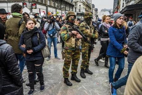 Soldiers stood guard as people paid their respects to the victims of multiple attacks across Brussels at Place de la Bourse.
