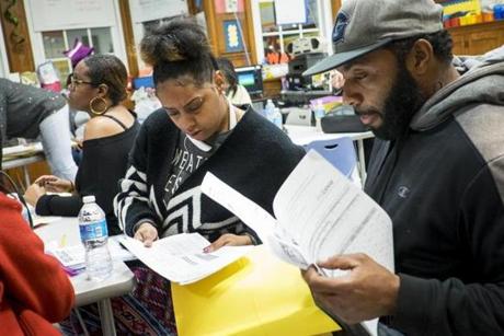 Kiyana Scott and Paul Bagby looked over their son's progress report during a parent-teacher conference at Beers Elementary School in Washington, D.C.
