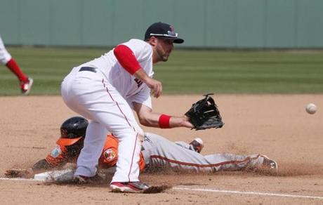 Boston Red Sox third baseman Travis Shaw, top, reaches out for the throw as Baltimore Orioles' Xavier Avery, bottom, steals the bag in the fifth inning of a spring training baseball game, Monday, March 28, 2016, in Fort Myers, Fla. (AP Photo/Tony Gutierrez)

