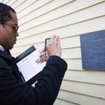 Renaldo Pearson, academic coordinator for Harvard College, took a photo of a plaque unveiled Wednesday at Wadsworth House, where four slaves had lived and worked.